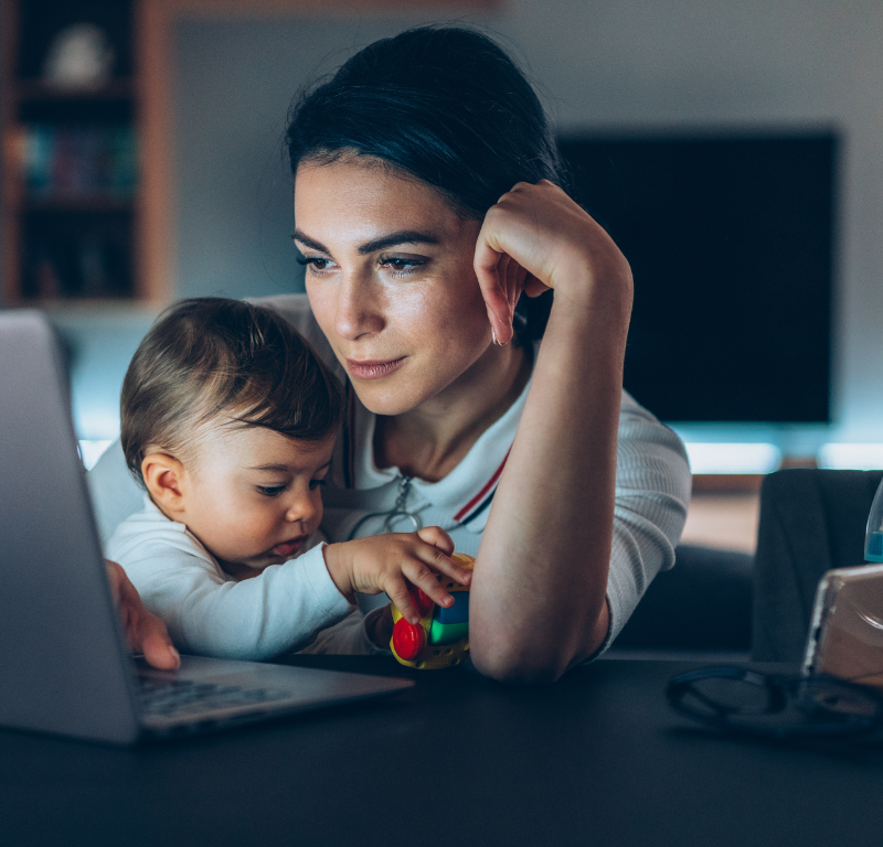 Mom working from home on her laptop with a baby in her lap.