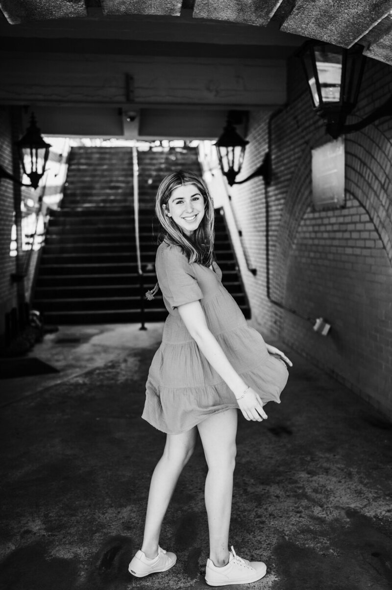 girl twirling wearing a dress in a train station