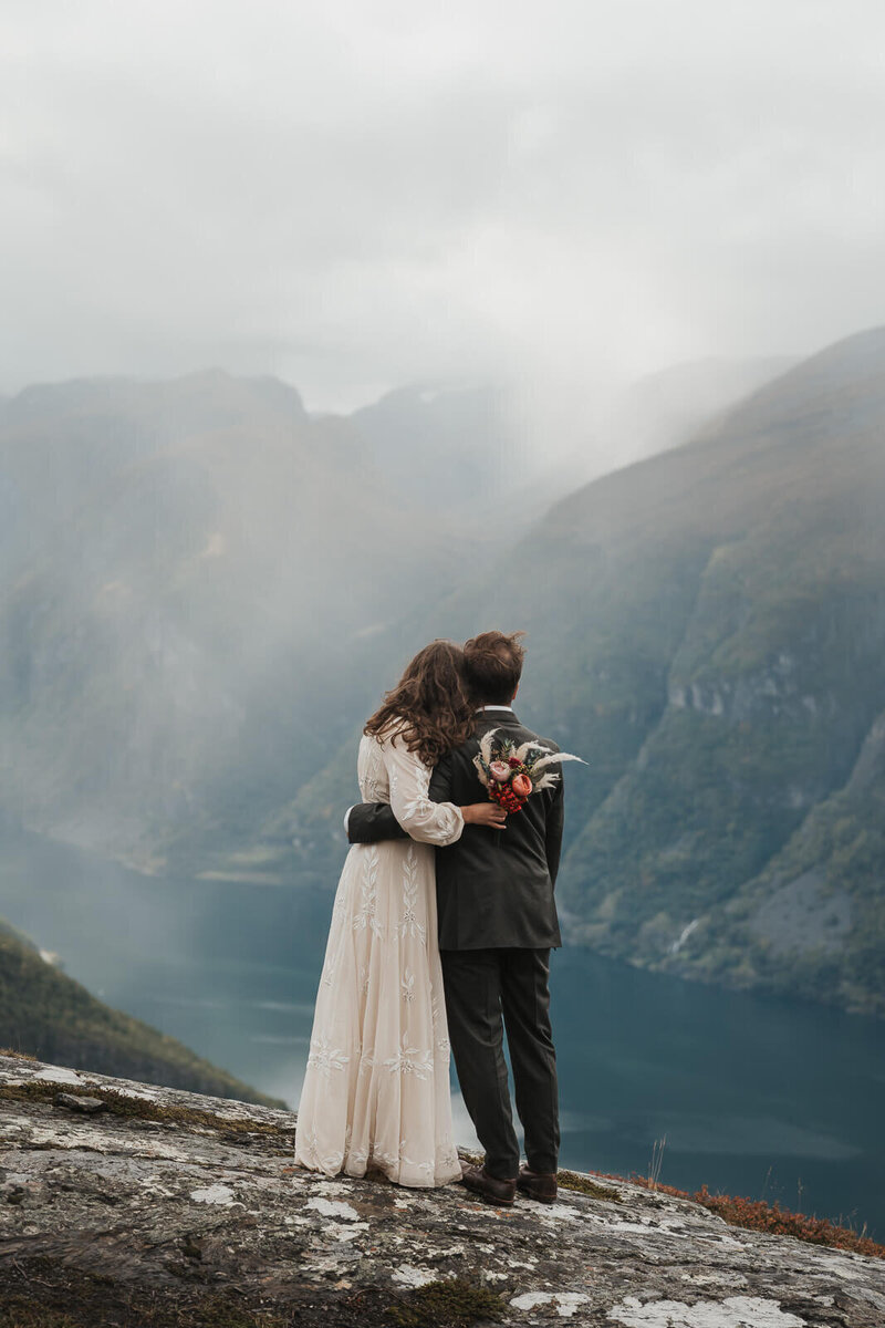 Wedding couple embracing in the sunset at the fjord in aurland
