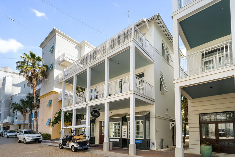 White coastal townhouse with private balconies at Carillon Beach Resort, close to shops and dining.