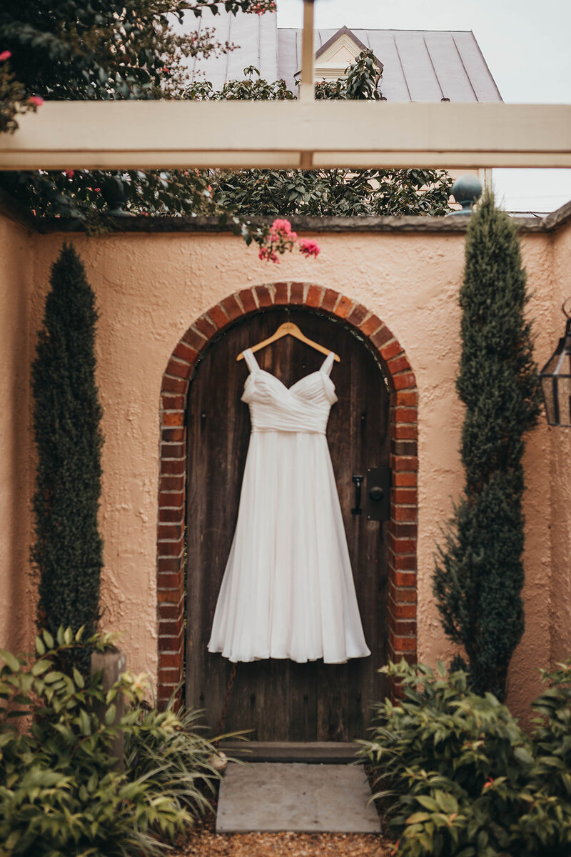 wedding dress hanging in front of spanish villa