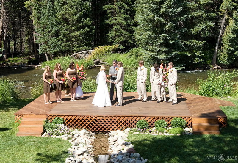 Outdoor wedding ceremony next to river and woods at Agape Outpost Chapel in Breckenridge CO