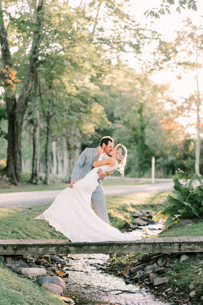Married couple kissing by creek