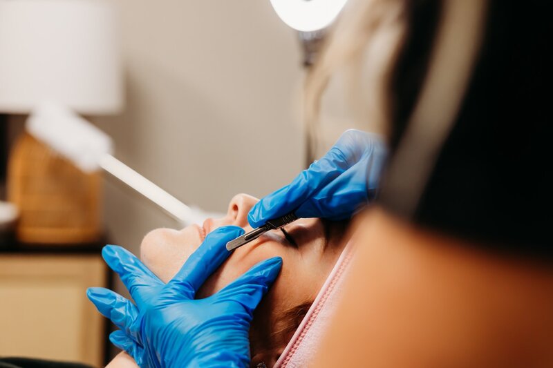 Esthetician giving woman a dermaplaning facial