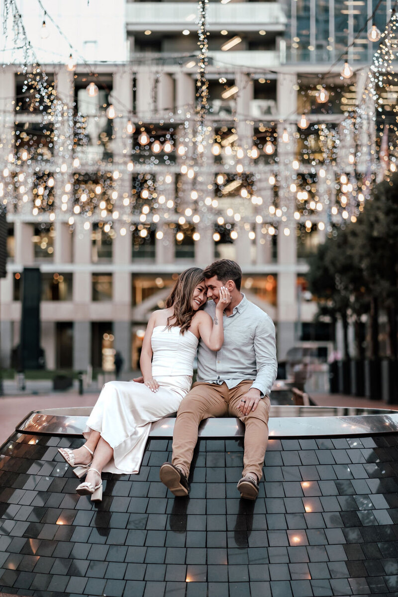 Romantic engagement photoshoot in Auckland city with fairy lights and couple sitting together, captured by Zanthe Vorsatz Photography.