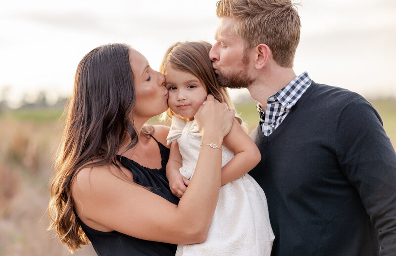 Mom and dad kissing girl