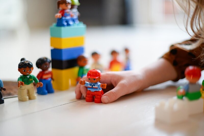small child playing with lego figures