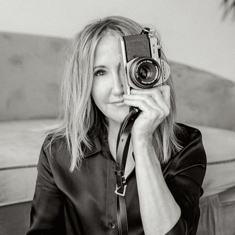 Black and white photo of a woman holding a camera