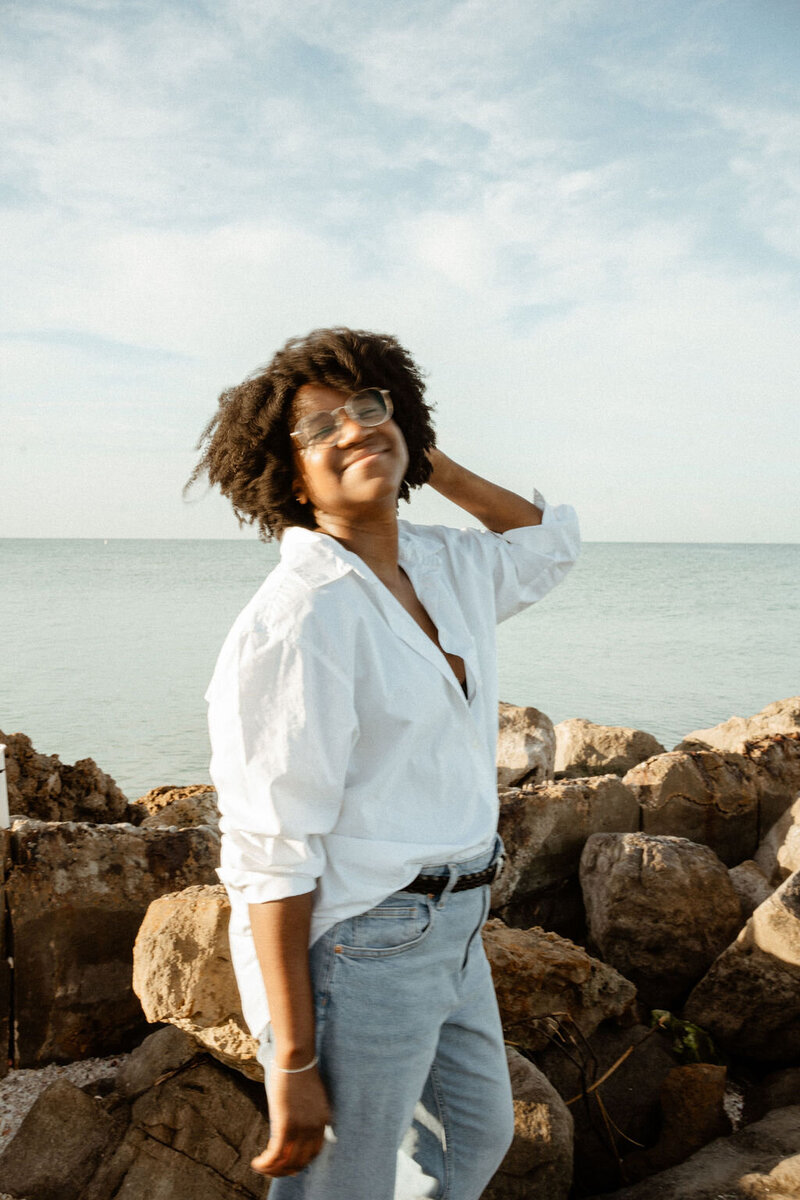 goal setting content creator smiling at the sun on the beach