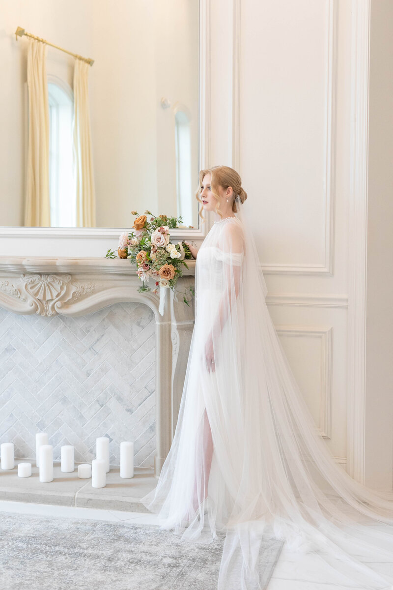timeless bride standing in front of marble fireplace
