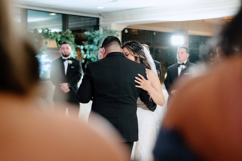 bride and groom during their first dance surrounded by loved ones - photo by Daniella Diaz Wedding Photographer