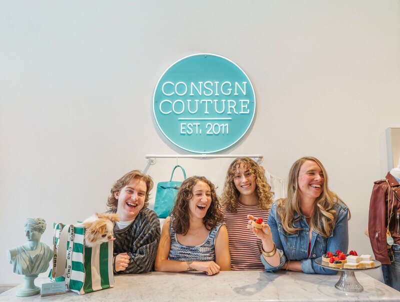 A person pulling a clothing rack across a sidewalk 