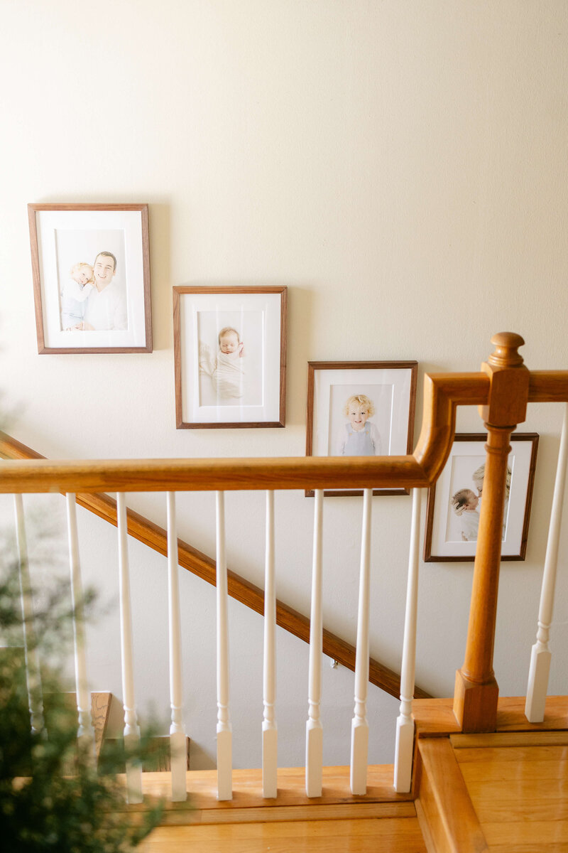 wooden framed family portraits going up the stairs