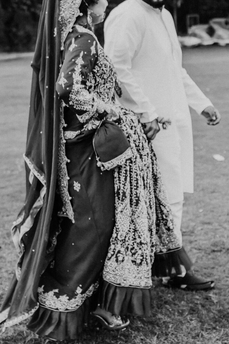 Muslim bride and groom walk hand in hand on their wedding day