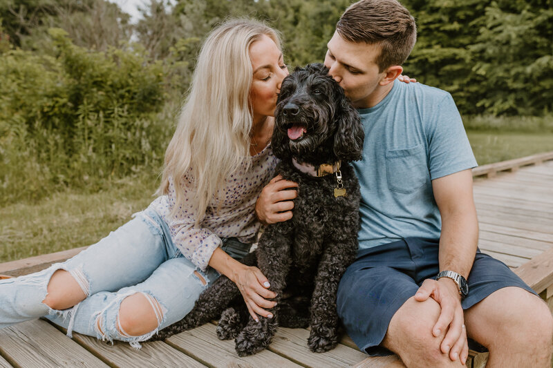 A couple kissing their dog