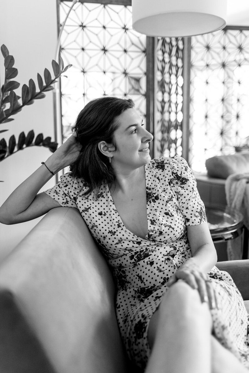 Black and white photo of Andrea Shah sitting on a sofa