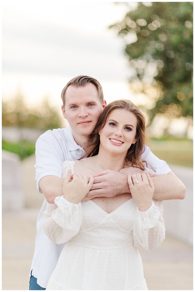 high school senior sits in a field for senior portraits