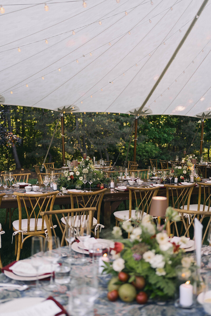 Reception tables beneath a sailcloth tent