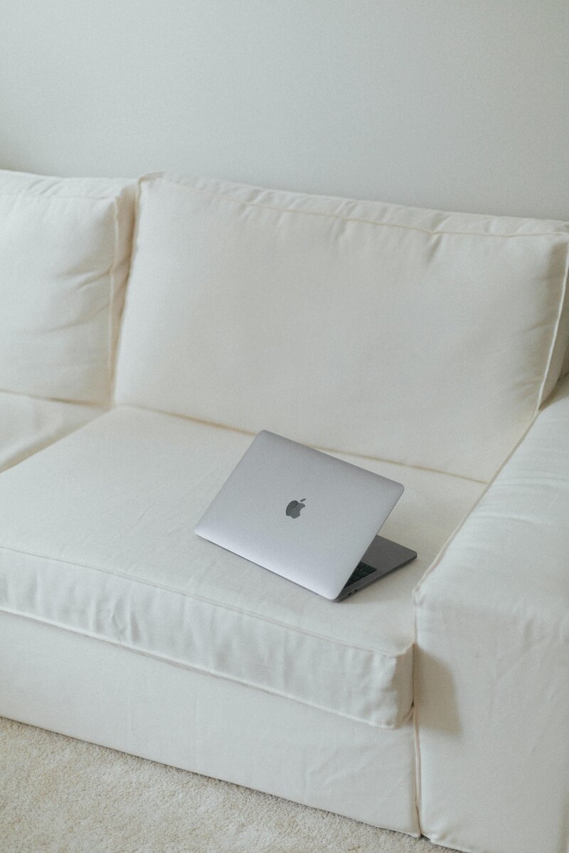 Macbook Pro laptop on top a white couch