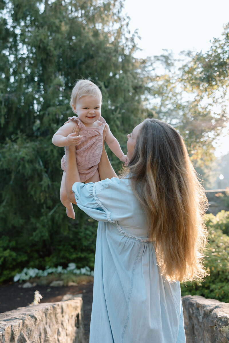 Mother lifts her infant daughter while she laughs