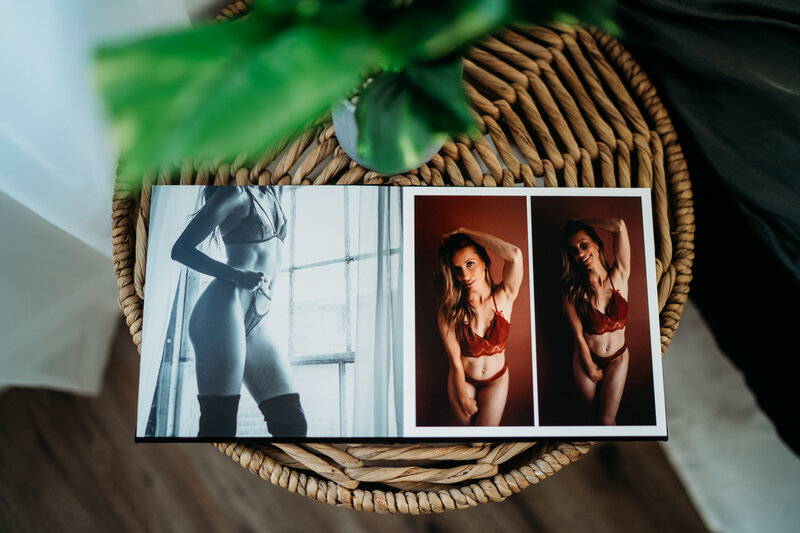 A mini photo album laying open on a wicker side table with pictures of women in lingerie