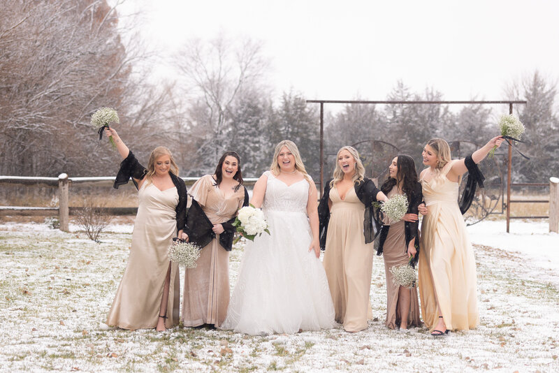 bride with bridesmaids walking while it snows