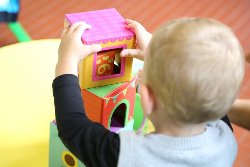 baby playing with colorful stacking toys
