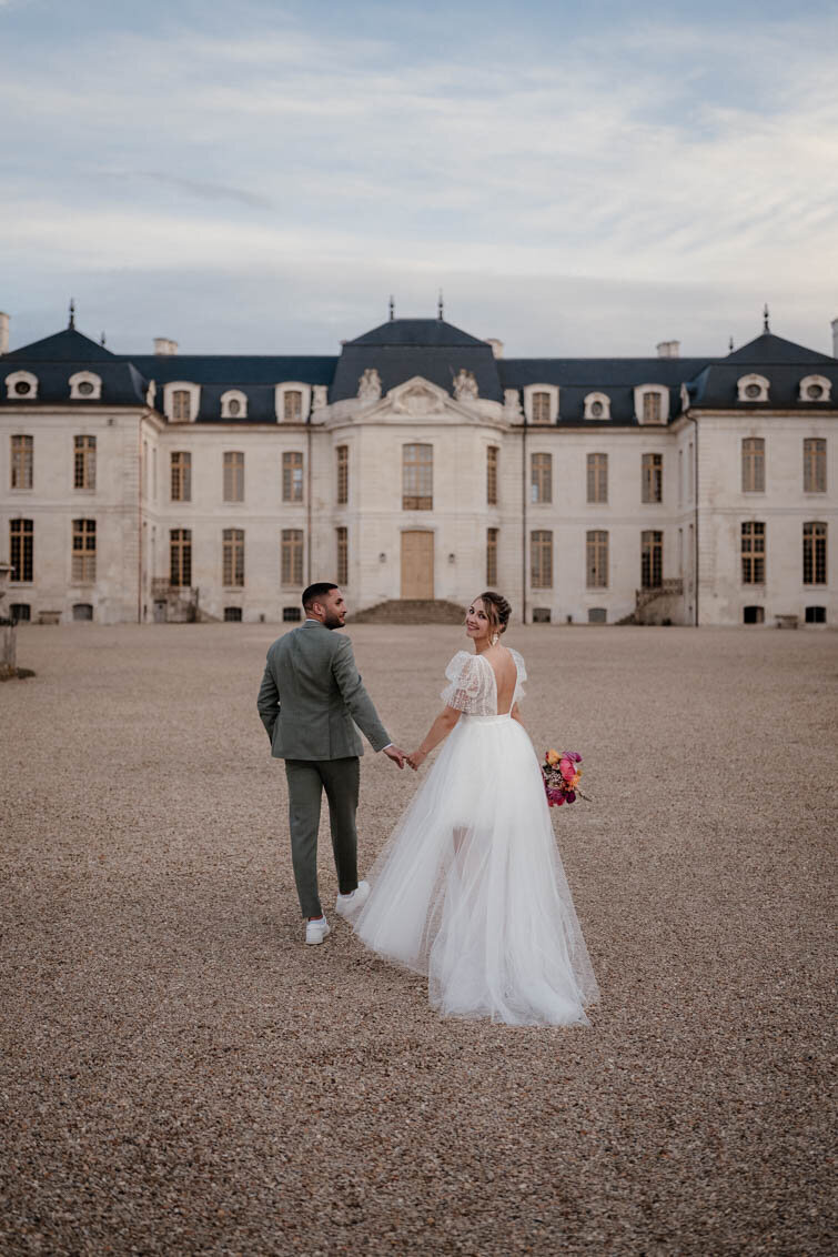 Séance photo et vidéo de couple à la golden hour devant le Château de Vaux, en Champagne – un moment intime et lumineux juste après la cérémonie”