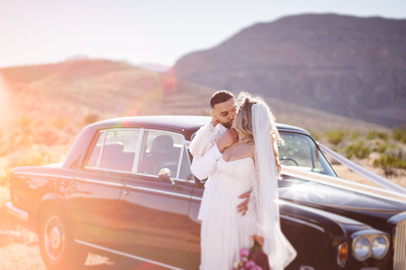 Couple kisses in front of vintage car during Las Vegas elopement