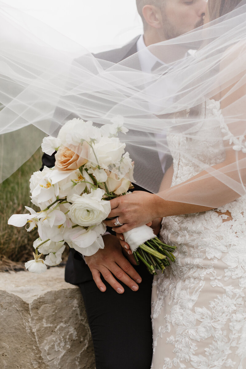 photo of bride and groom embracing while bride holds wedding bouquet taken by Affordable wedding photographer Milwaukee