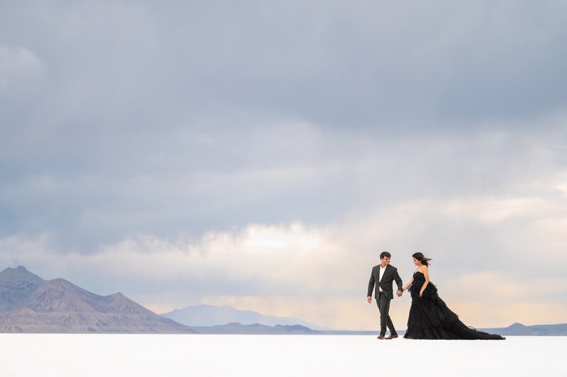 Indian couple walking along the Salt Flats in classy black formal attire.