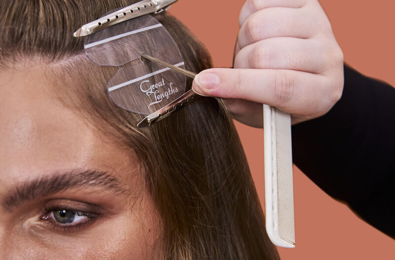 Stylist attaching Great Lengths hair extensions in a professional North Shore hair salon.