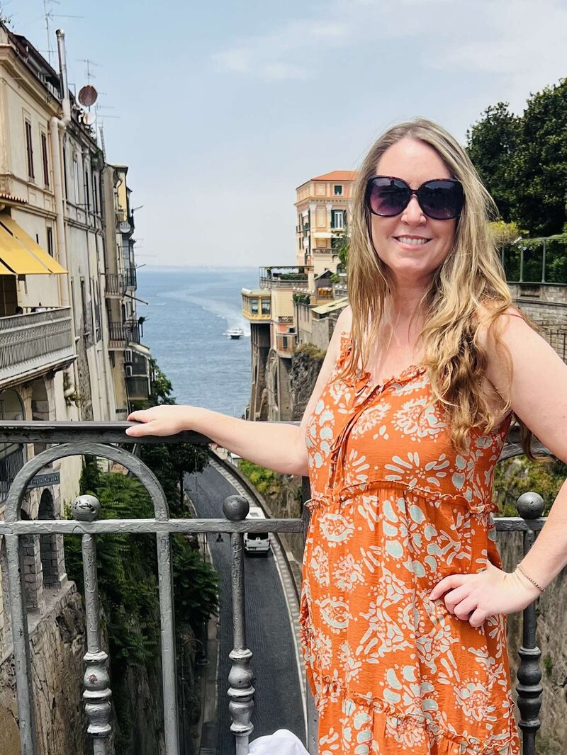Terra, founder of Adventures by Terra, in Cinque Terre, Italy, with the buildings behind her up on a cliff