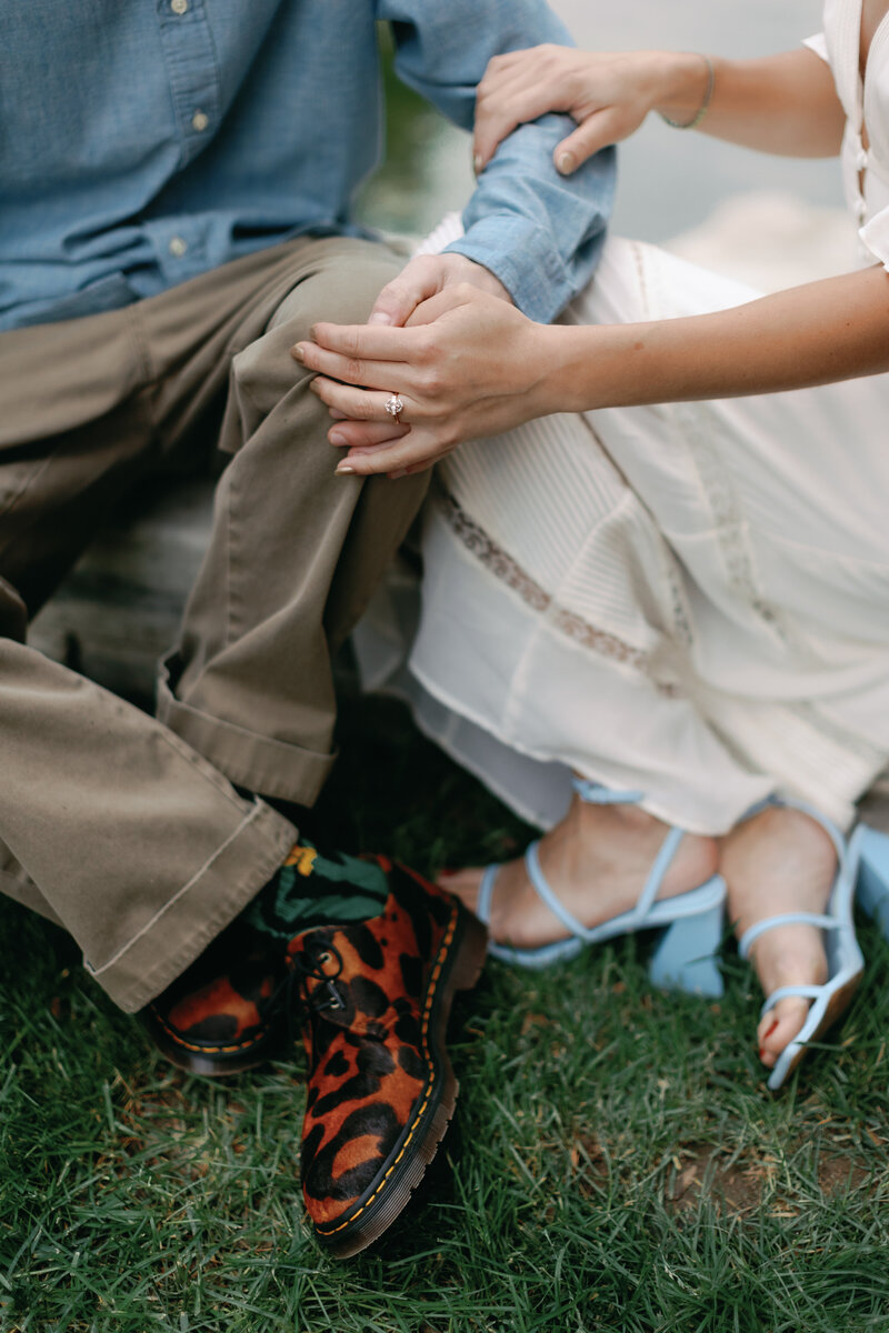 A couples holds hands during their downtown park engagement session
