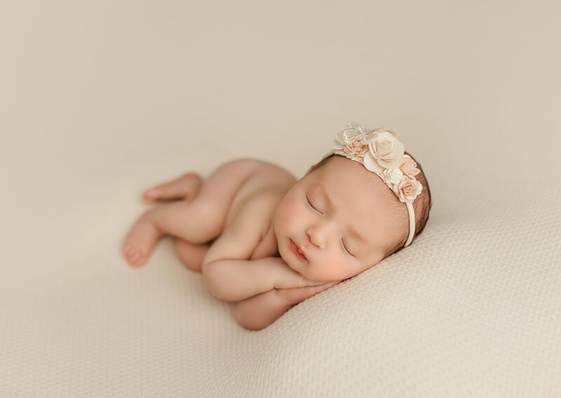 Timeless newborn portrait created with soft directional studio light, warm tones, and elegant fine-art styling.