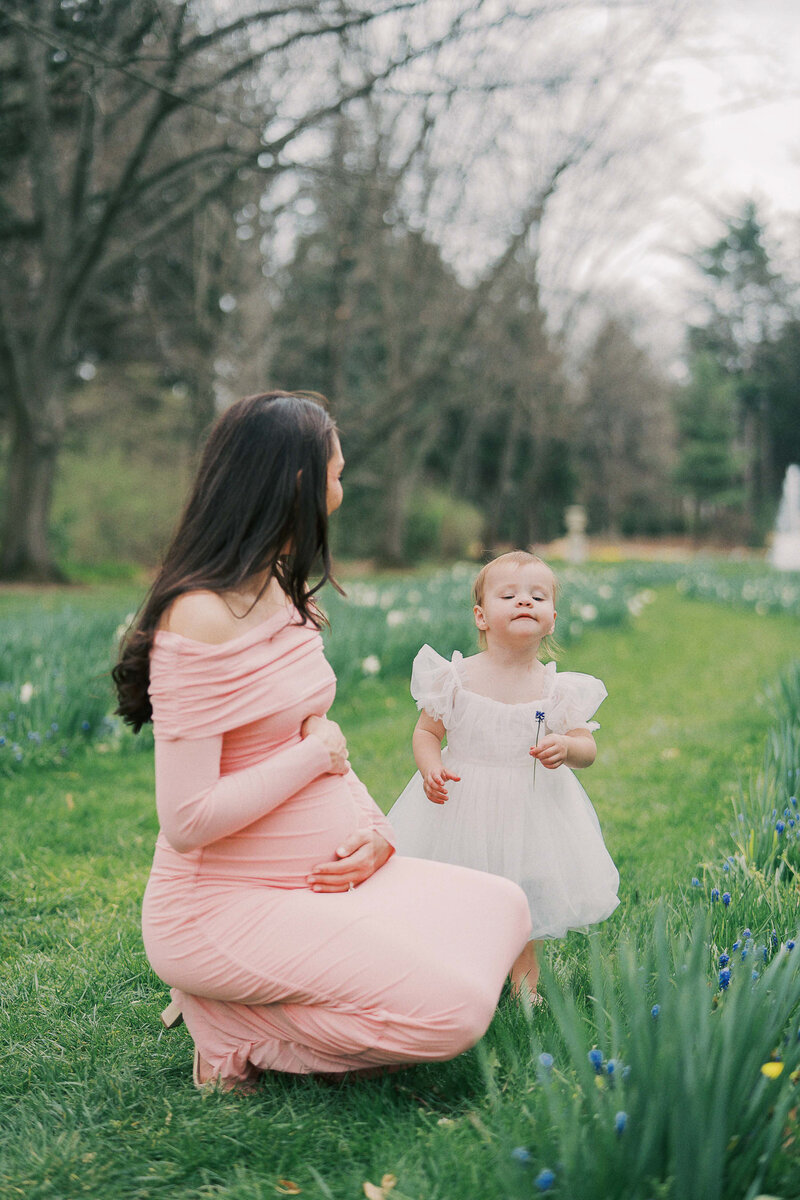 an expecting mom playing with her toddler daughter