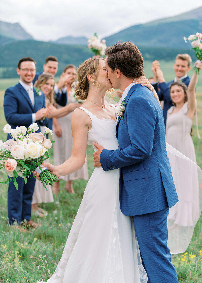 groom and bride kissing in fornt of bridal party taken by Colorado Springs Wedding Photographer Erin Winter