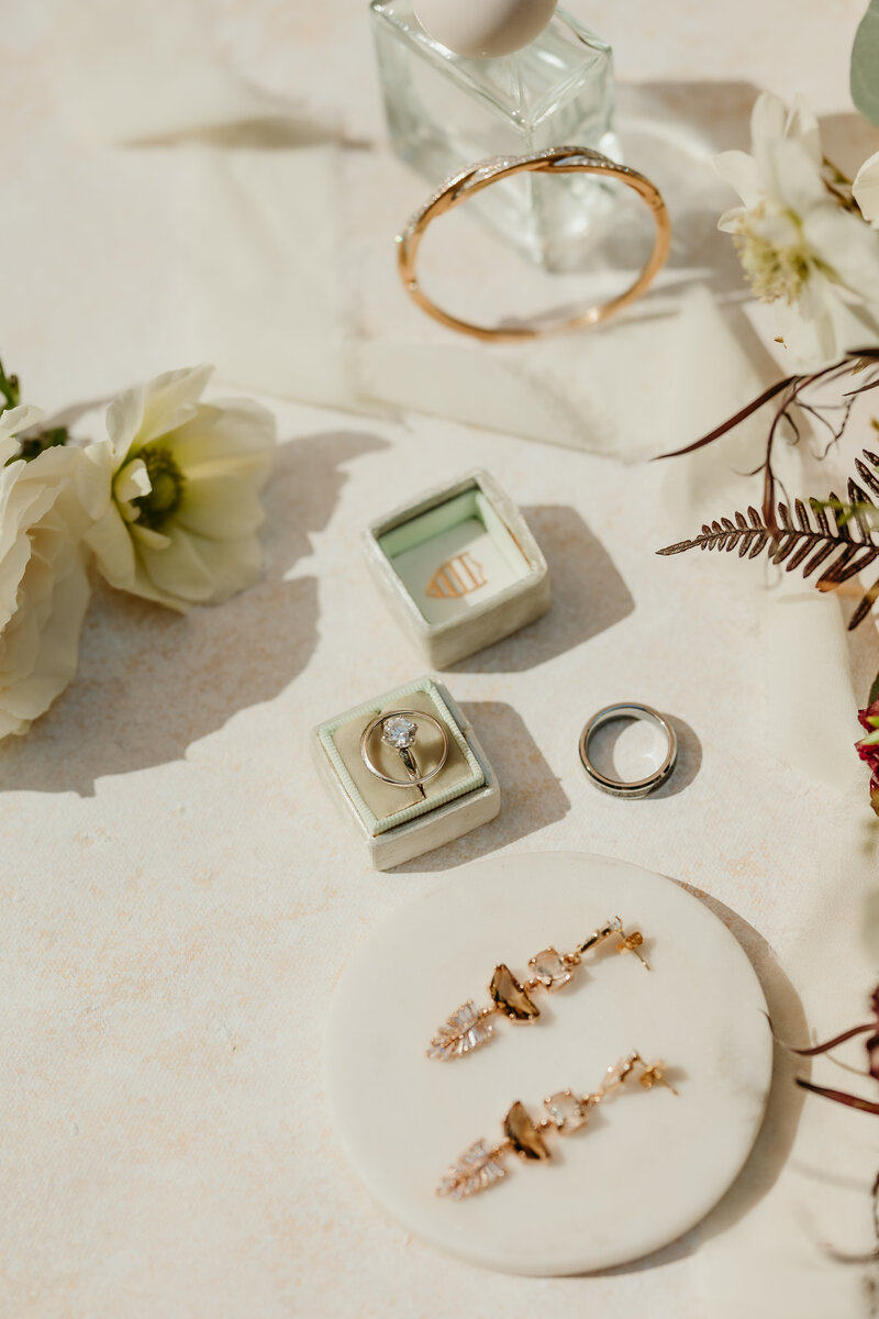 Her most treasured details in a modern and sleek flat lay like her earrings, engagement rings and perfume