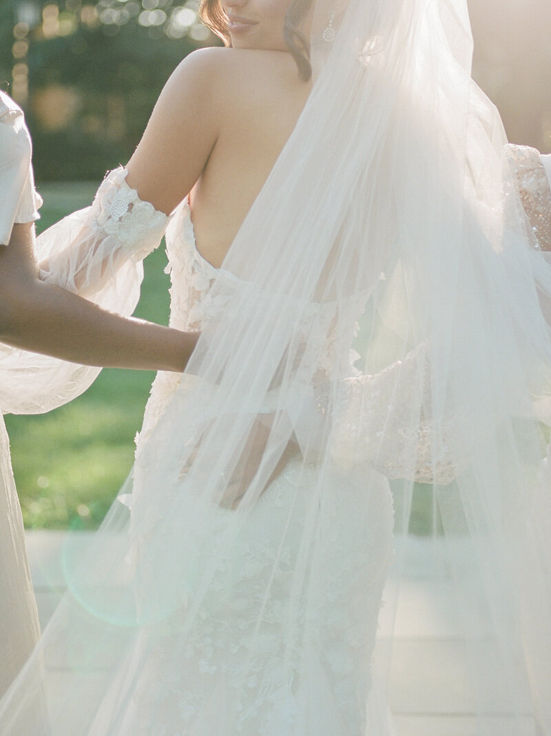 Luminous light through bride's lace dress and long veil at a Greencrest Manor wedding in Michigan