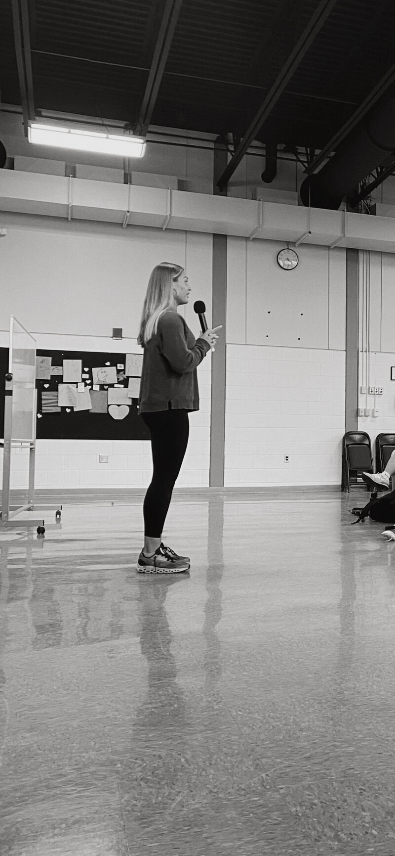 a female in front of a group of people speaking. 