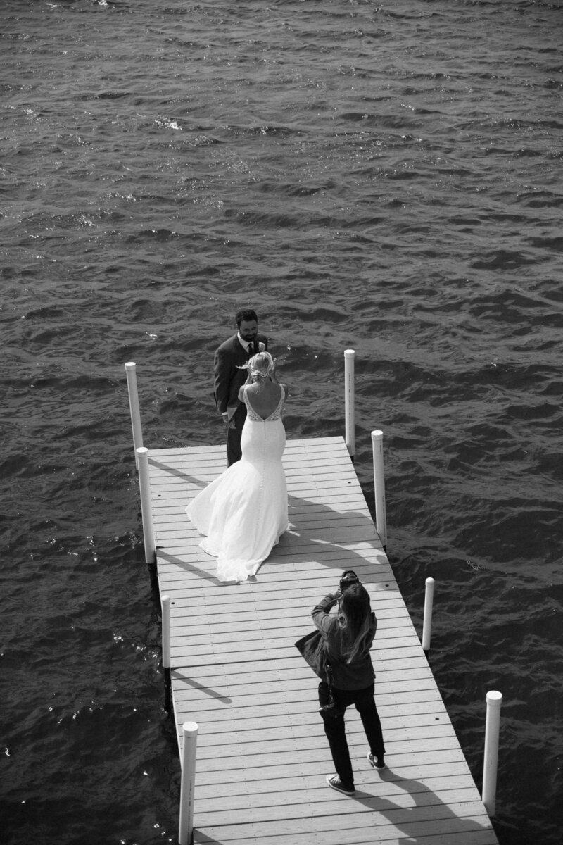 Photographer photographing couple by the water