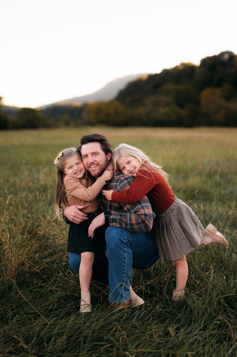father and daughters hugging in open field chattanooga
