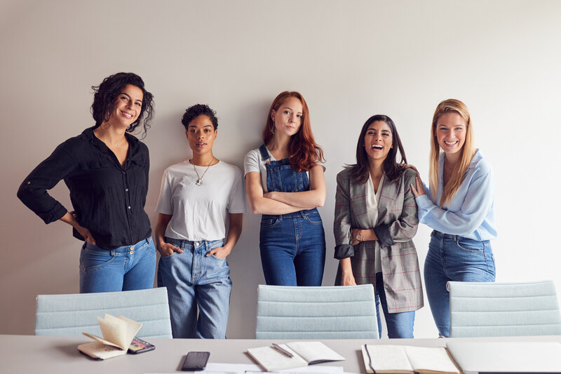 Collective group of women smiling and laughing at camera during book club