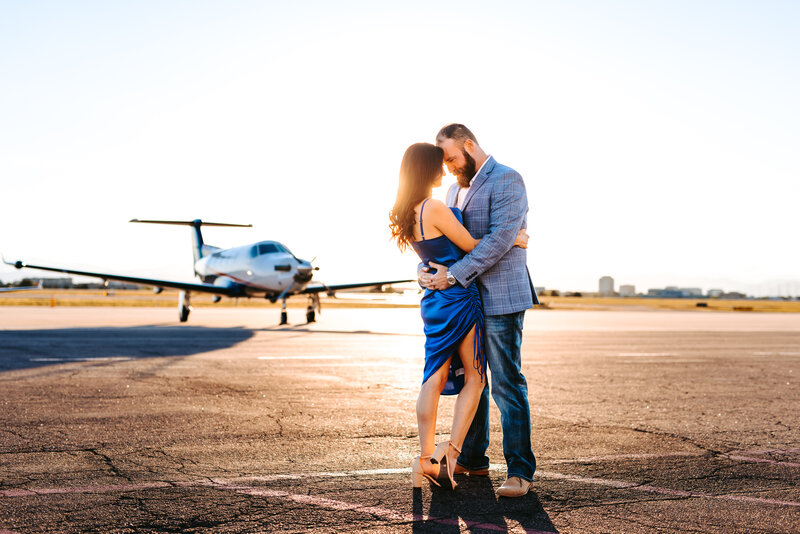 Couple on tarmac of airport for sunset surprise proposal