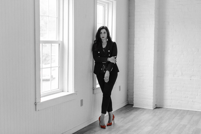 Erin Dimitriou Headshot Black and white with red heels