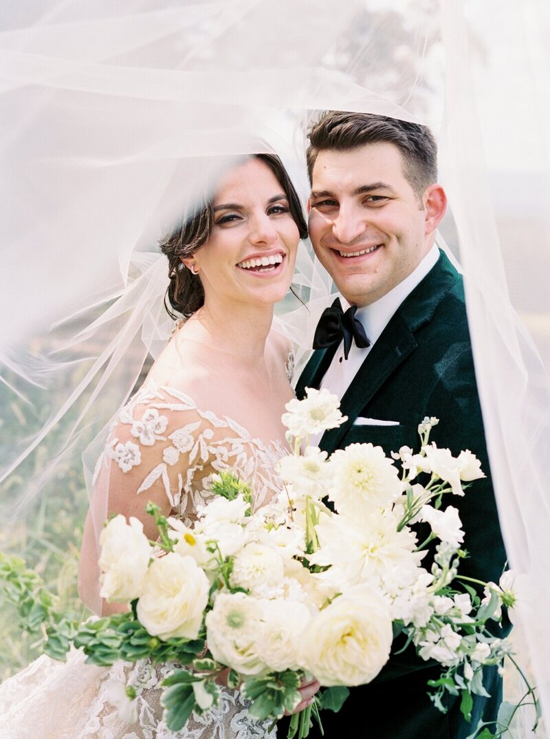 Bride and groom under veil with lush white bouquet – Fine Art Wedding Photographer Seattle