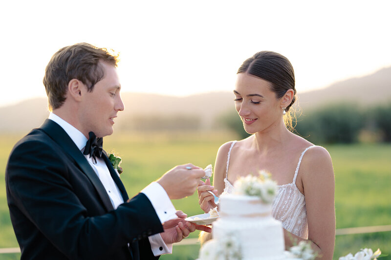 Couple walks beside pond with reflection at their Diamond Cross Ranch Wedding with photography by Foxtails Photography