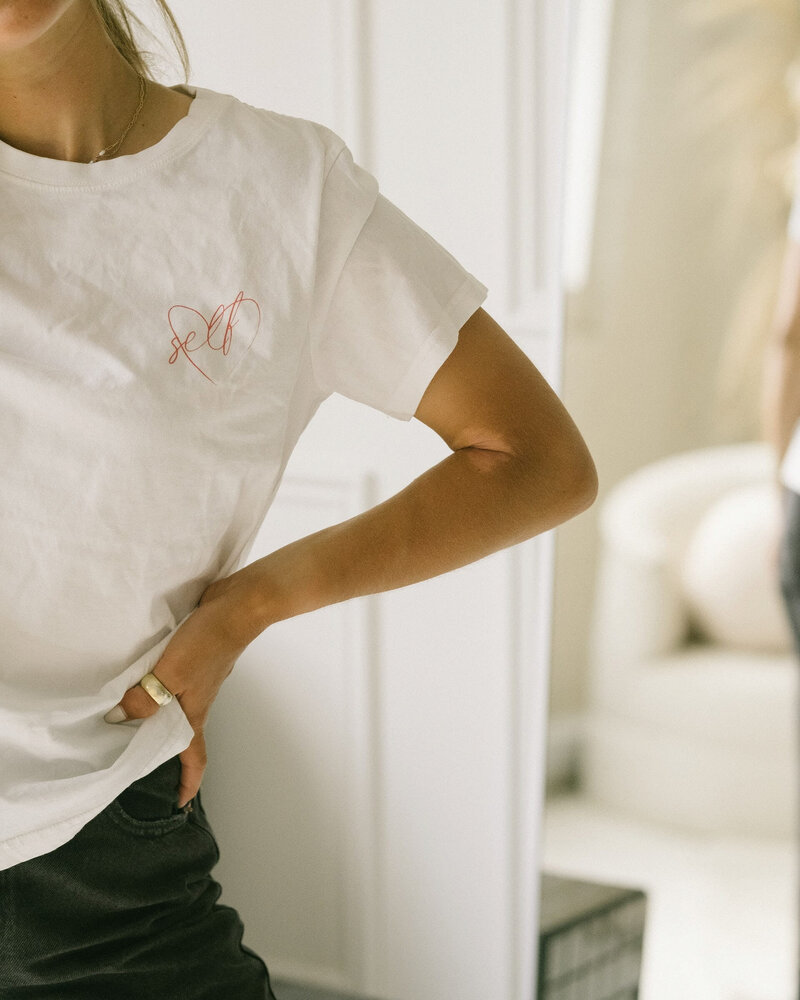 Femme en t shirt blanc avec une main sur la hanche