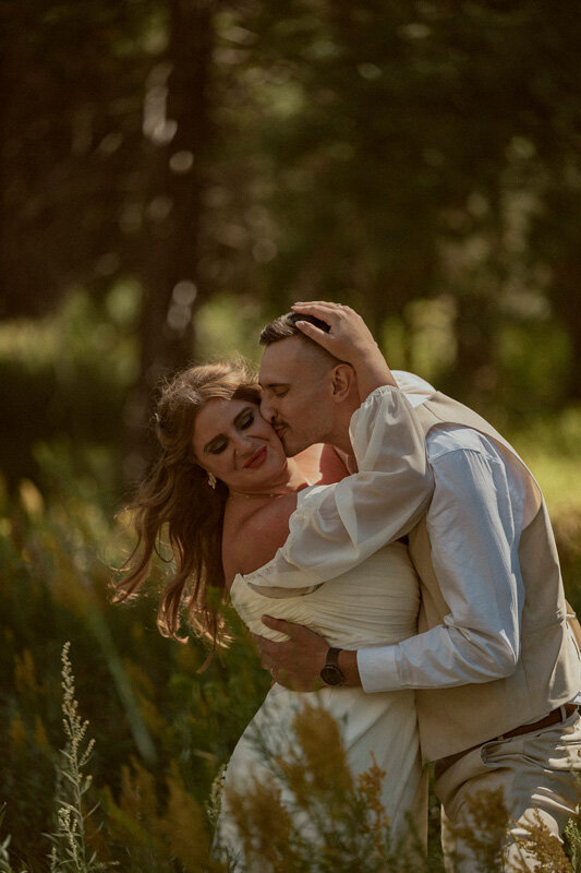 bride and groom kissing in a meadow on their yosemite wedding day