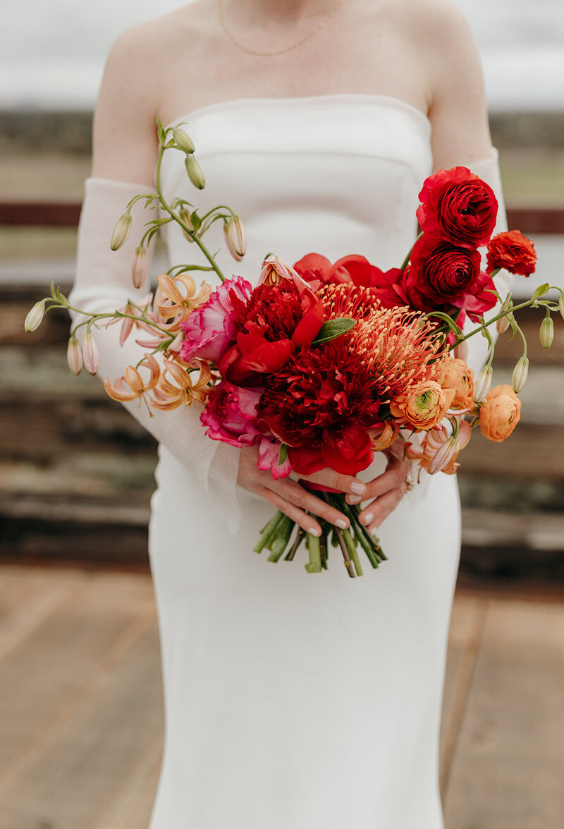 Spring wedding bouquet with protea, lilies, and garden roses
